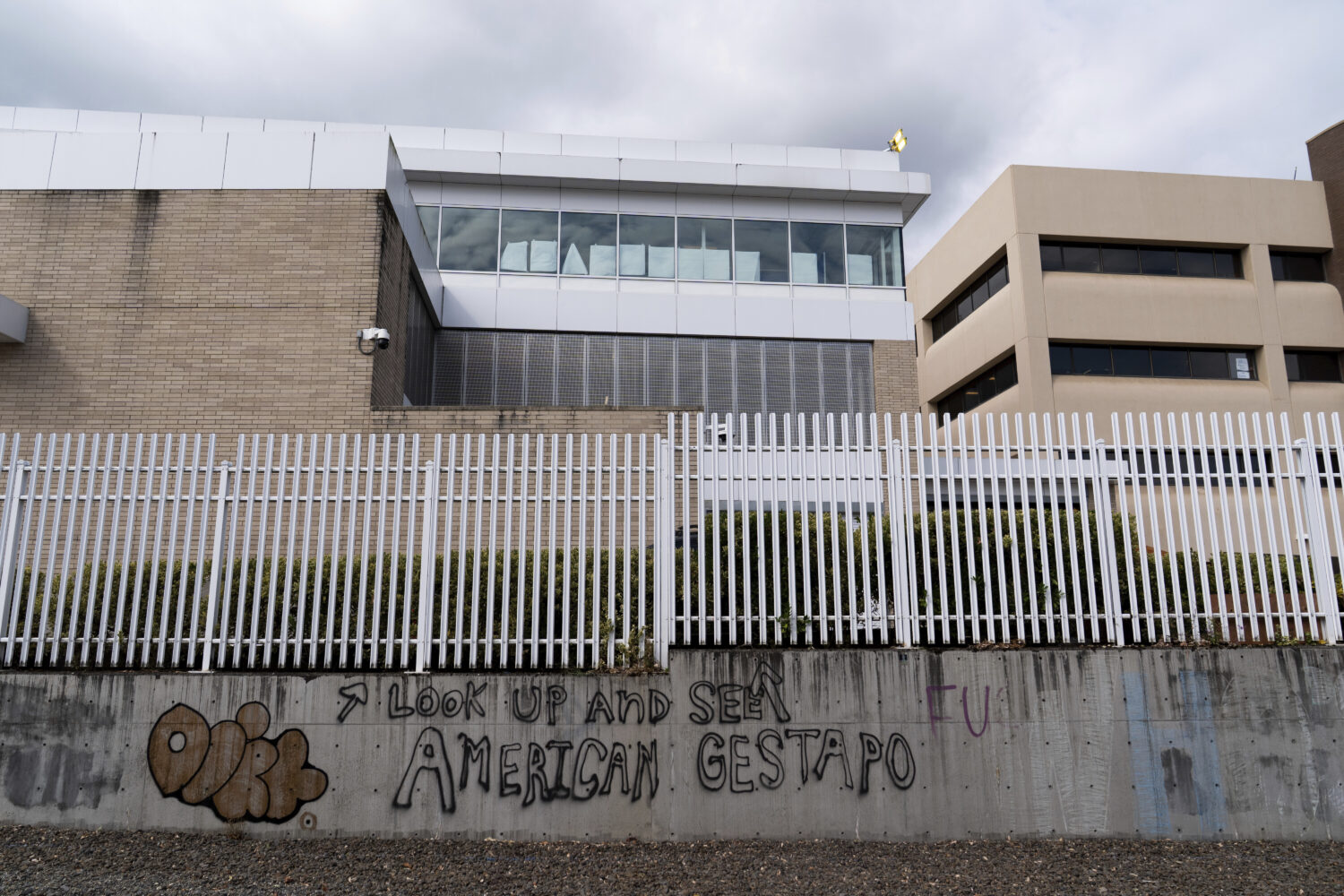 Graffiti is seen outside the U.S. Immigration and Customs Enforcement building in Portland, Ore., o...