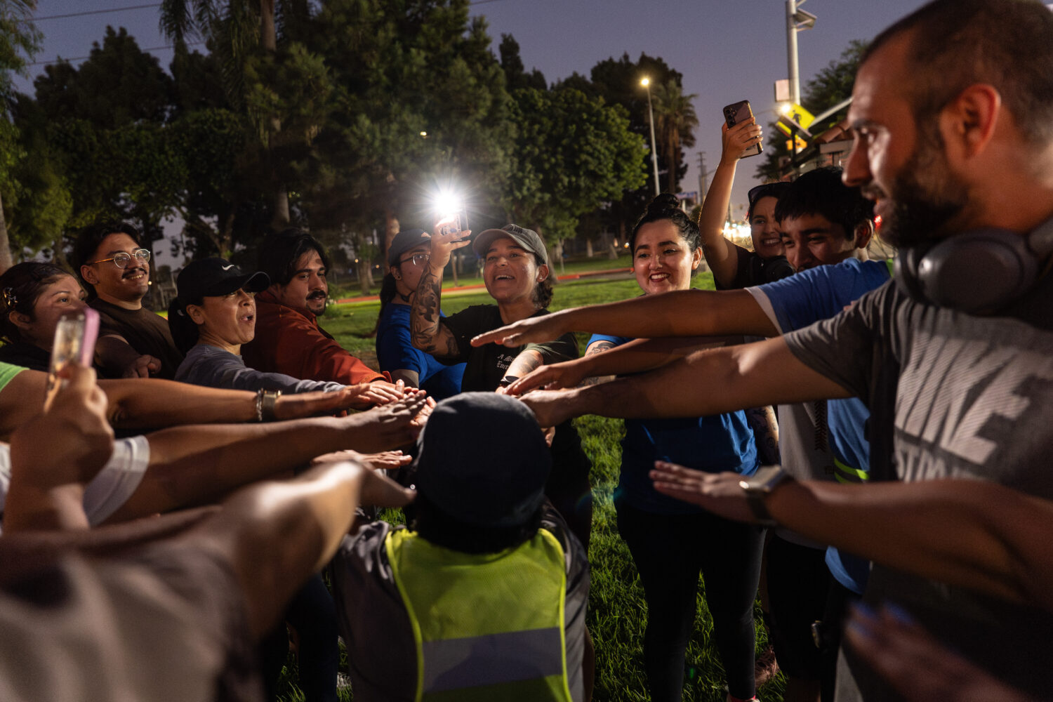 Iris Delgado, center, founder of the Huntington Park Run Club, leads a huddle after their run in Hu...
