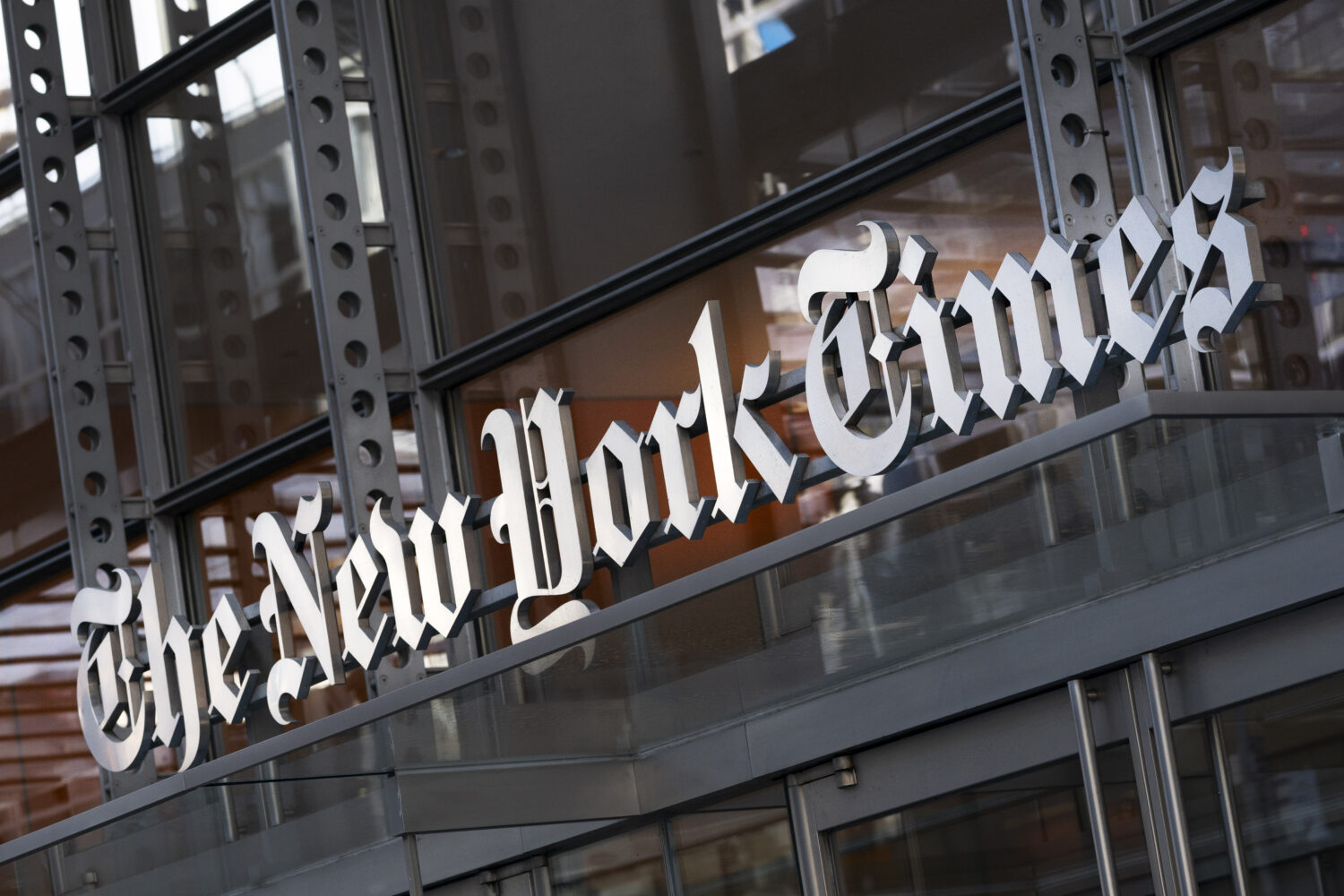 FILE - A sign for The New York Times hangs above the entrance to its building, May 6, 2021, in New ...