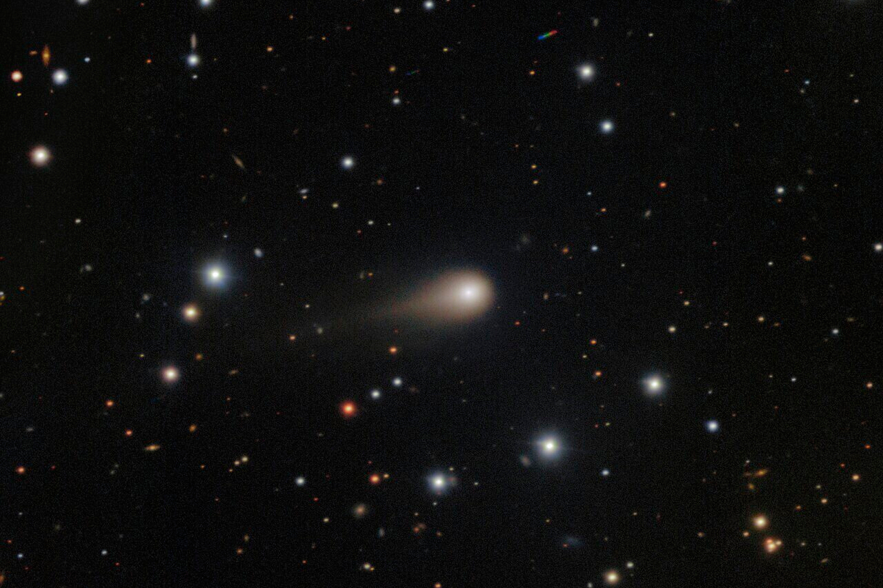 This image composed from multiple exposures and provided by NSF's NOIRLab shows a comet streaking a...