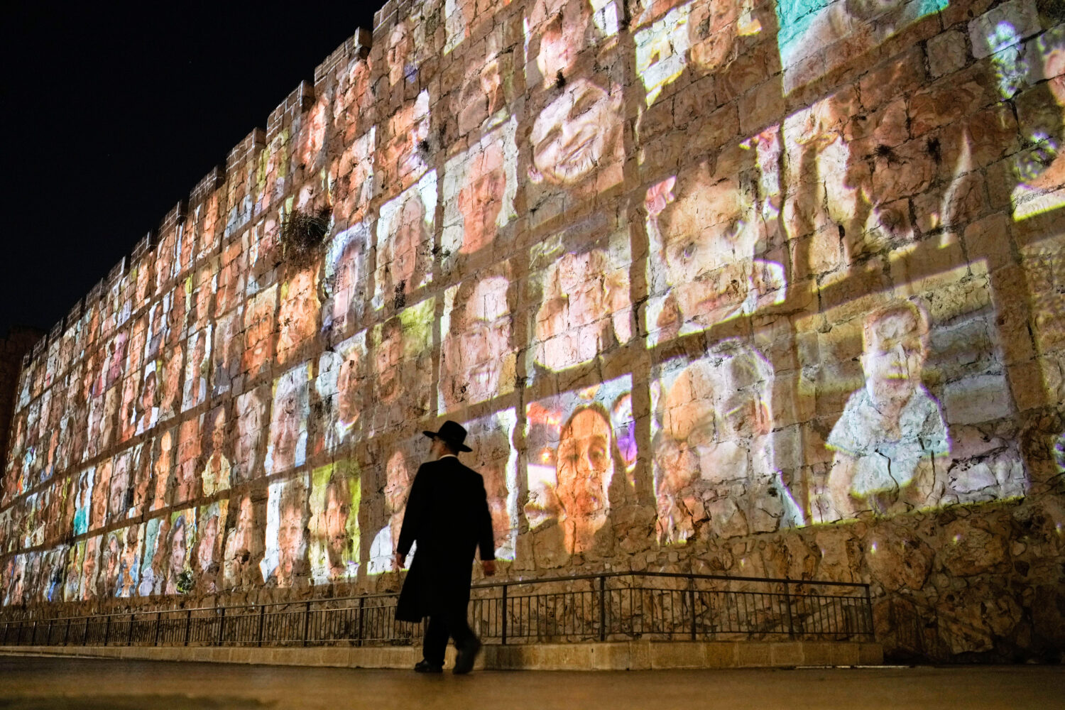FILE - Photographs of Israeli hostages being held by Hamas militants are projected on the walls of ...