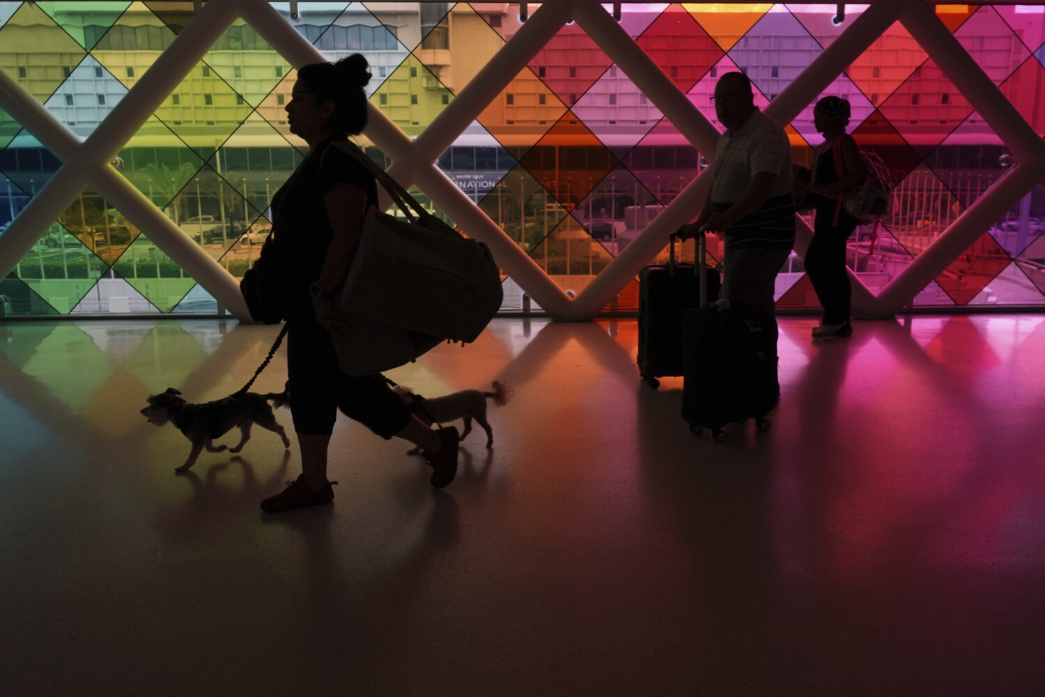 Travelers walk toward an exit at Miami International Airport at the start of the Labor Day weekend,...