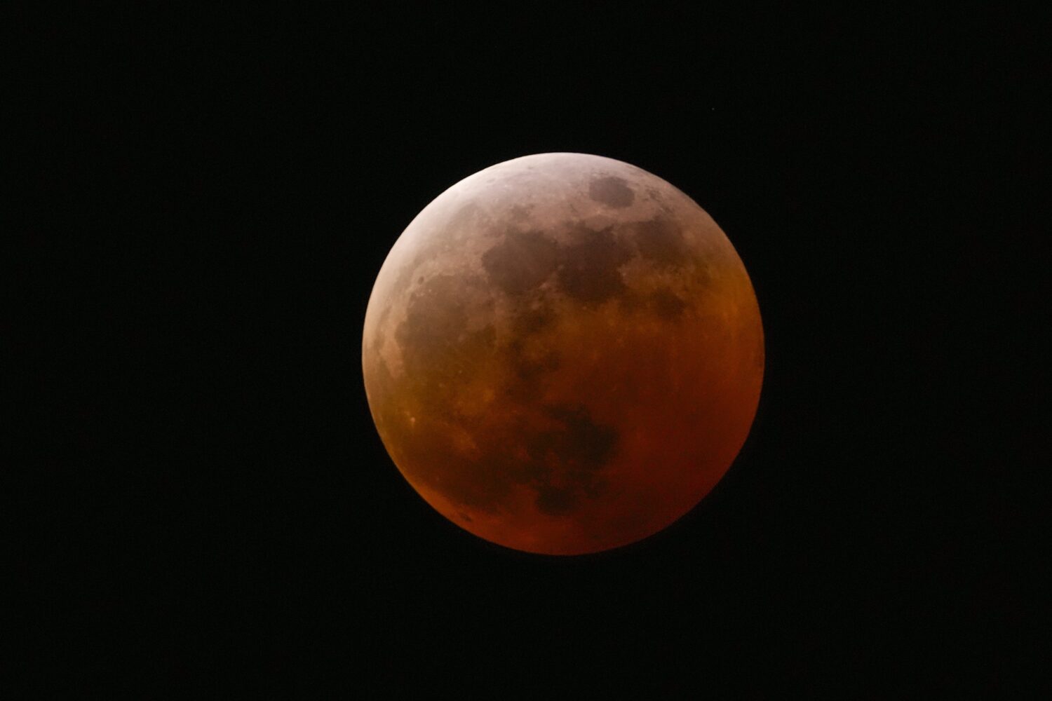 FILE - The moon shines over Mexico City during a total lunar eclipse, in Mexico City, Friday, March...