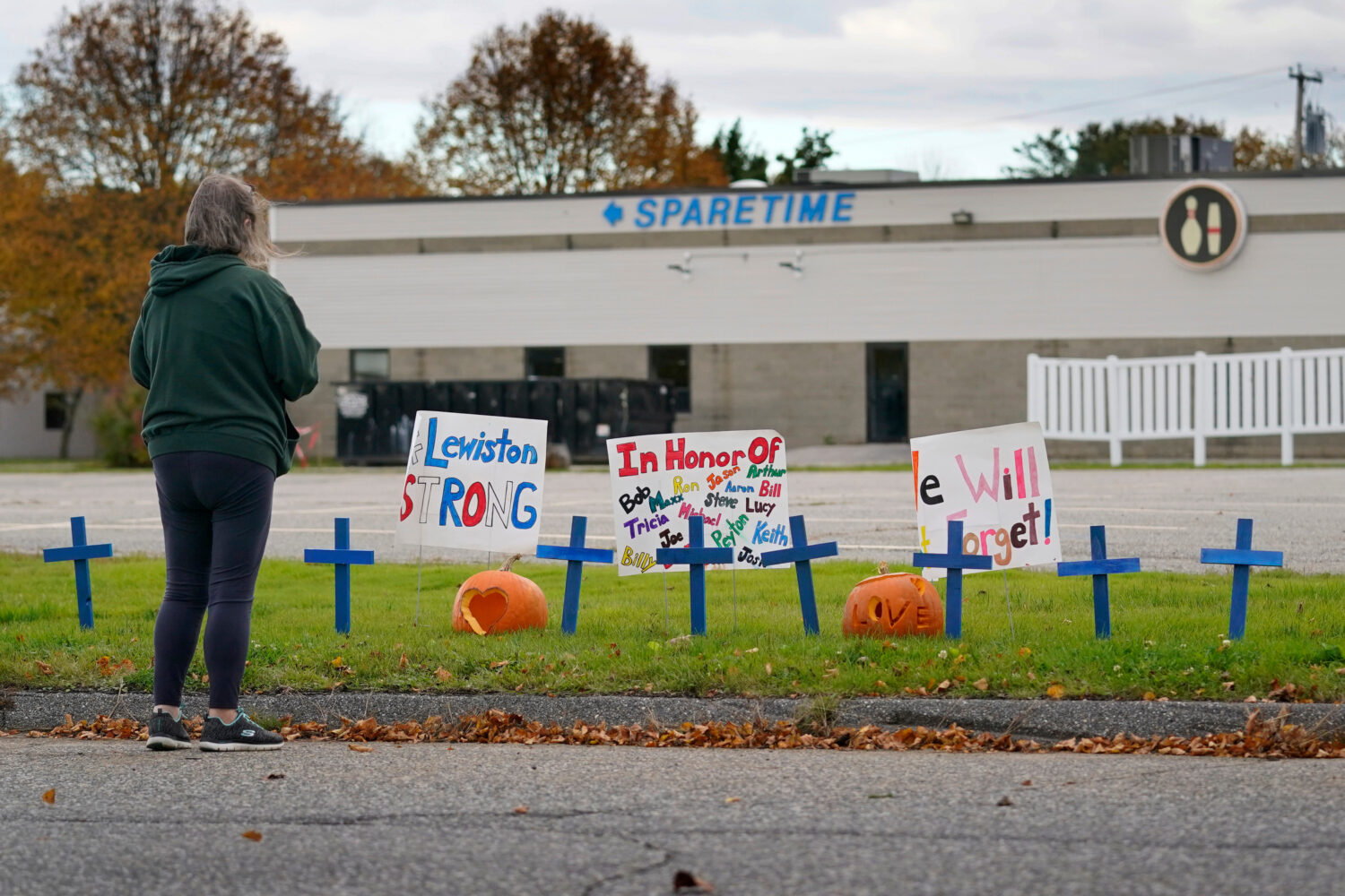 FILE - A woman visits a makeshift memorial outside Sparetime Bowling Alley, the site of a mass shoo...