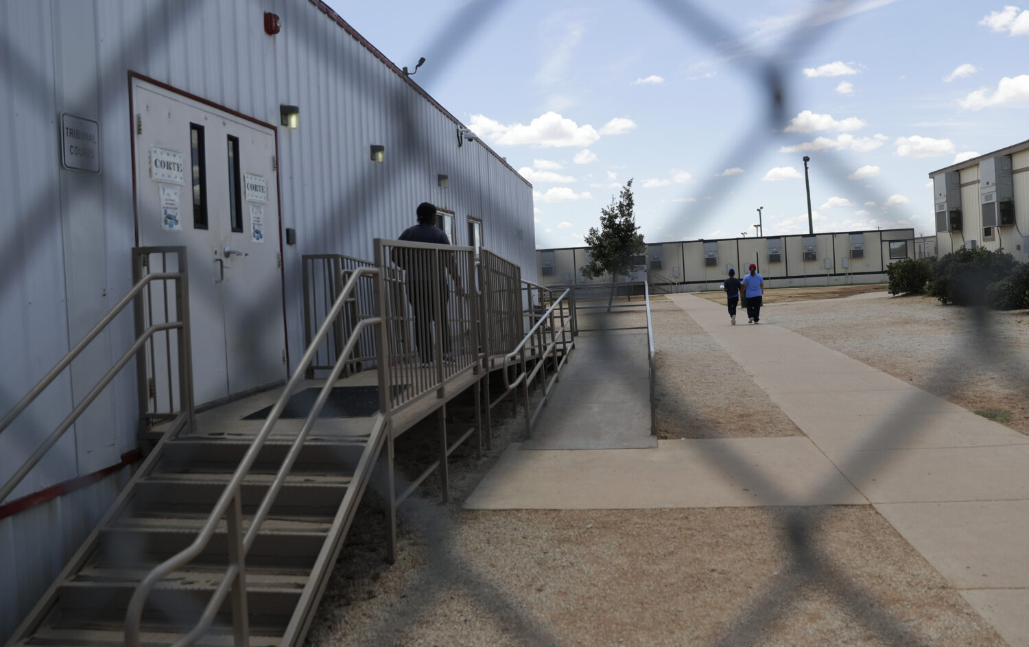 FILE - Immigrants seeking asylum walk at the ICE South Texas Family Residential Center, on Aug. 23,...
