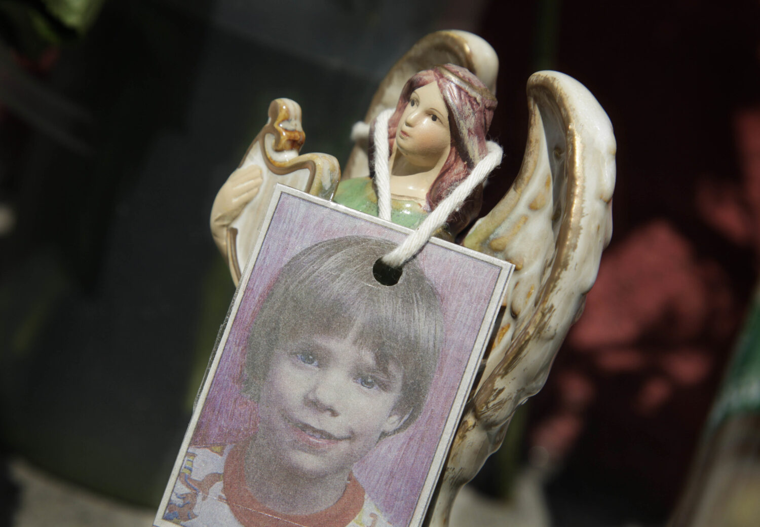 FILE - A photograph of Etan Patz hangs on an angel figurine, as part of a makeshift memorial in the...