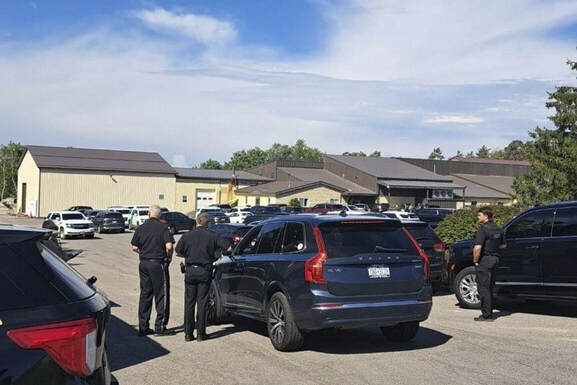 In this photo provided by Rural & Migrant Ministry, law enforcement officers gather outside during ...