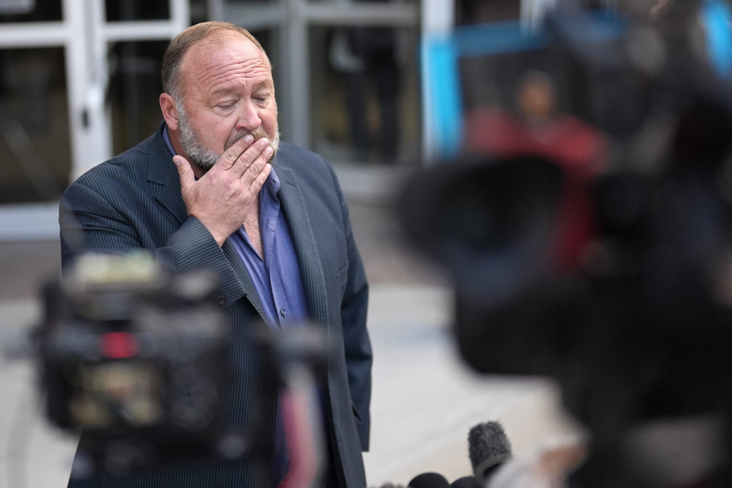 FILE - Alex Jones pauses before speaking to the media after arriving at the federal courthouse for ...