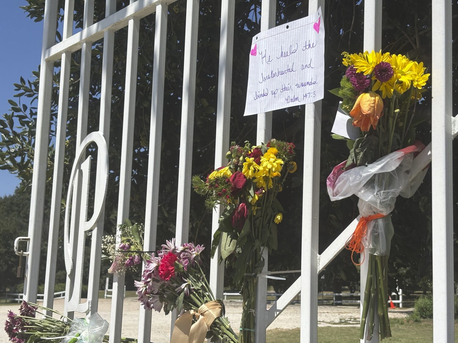 Flowers and memorial notes hang from the gate to Kiesel Park in Auburn, Ala., Tuesday Sept. 9, 2025...