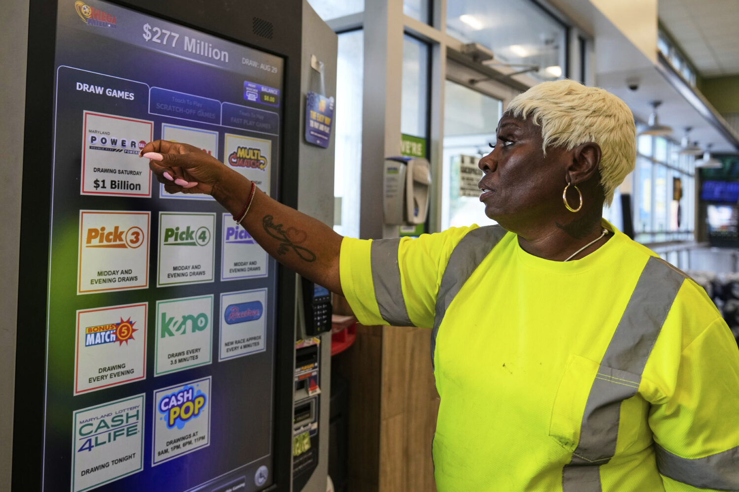 Roslyn Jefferson makes her lottery ticket selections on a self-serve terminal inside a gas station ...