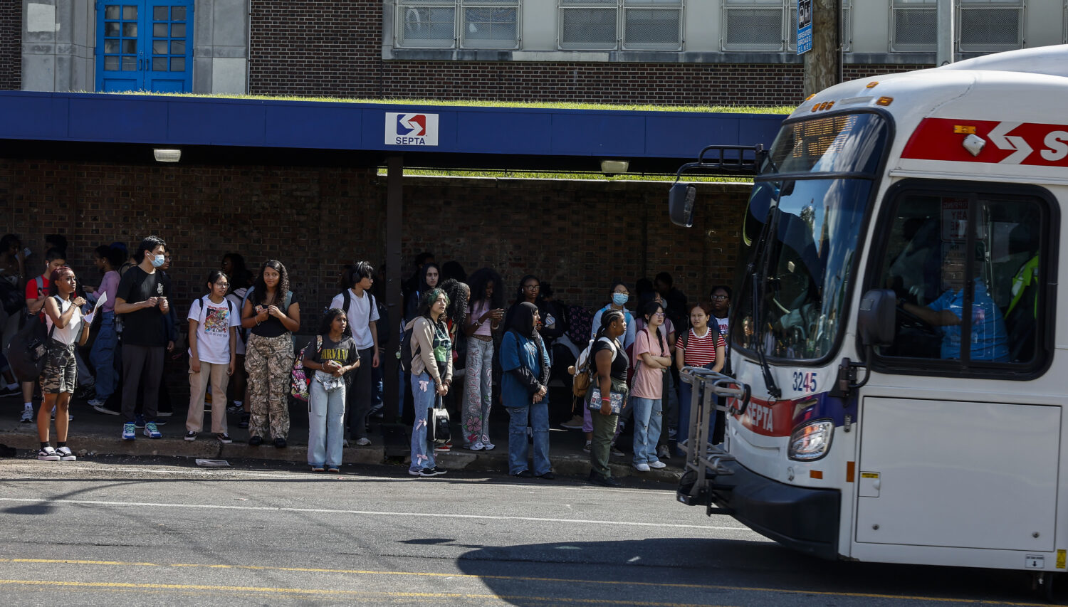 Students watch as a 26 bus passes the stop near Girls High at Broad and Olney streets Monday, Aug. ...
