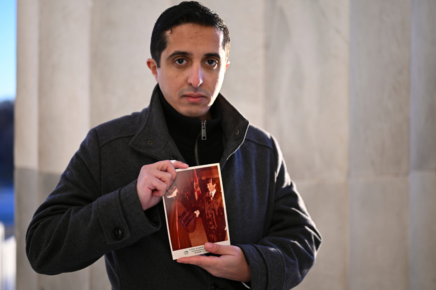 FILE - Ibrahim Almadi holds a photo of his father Saad Almadi graduating from college in 1984, in W...