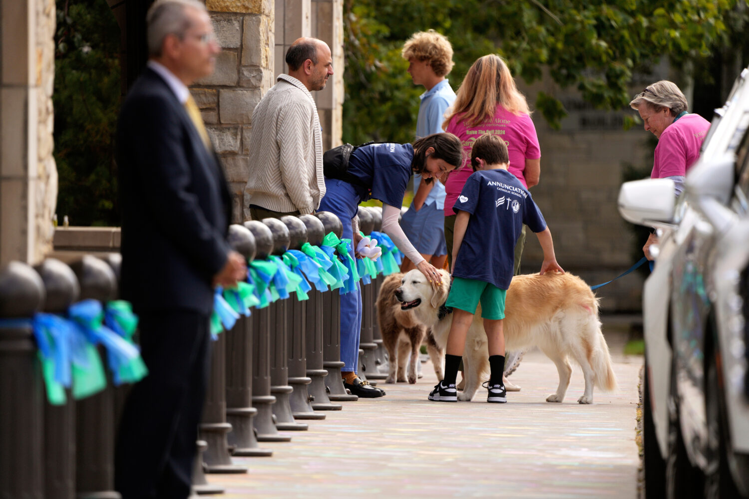 Attendees are greeted by support dogs outside of Mt. Olivet Lutheran Church for the funeral of 8-ye...