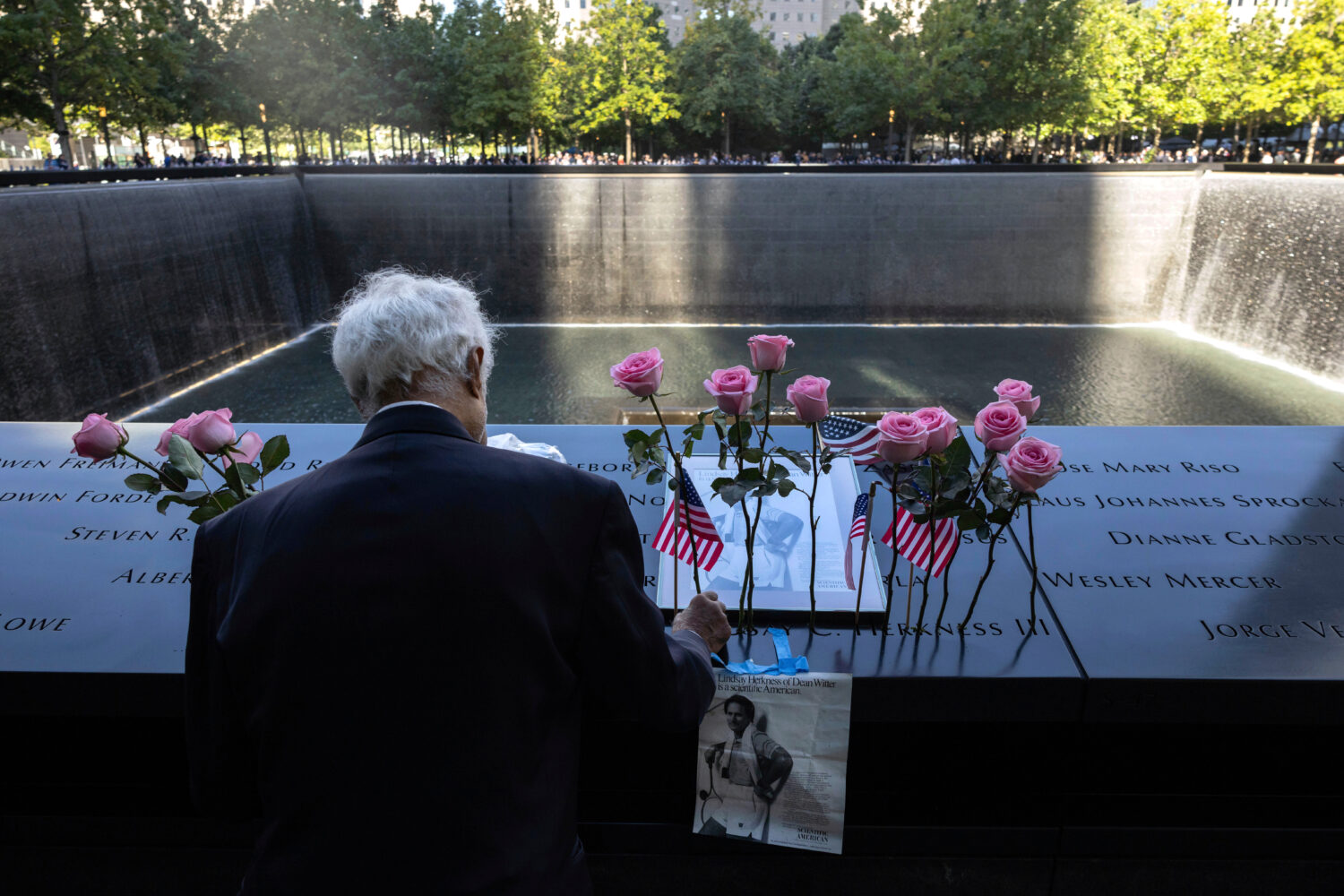 FILE - Hagi Abucar places flowers for his former coworker Lindsey Herkness on the south reflecting ...