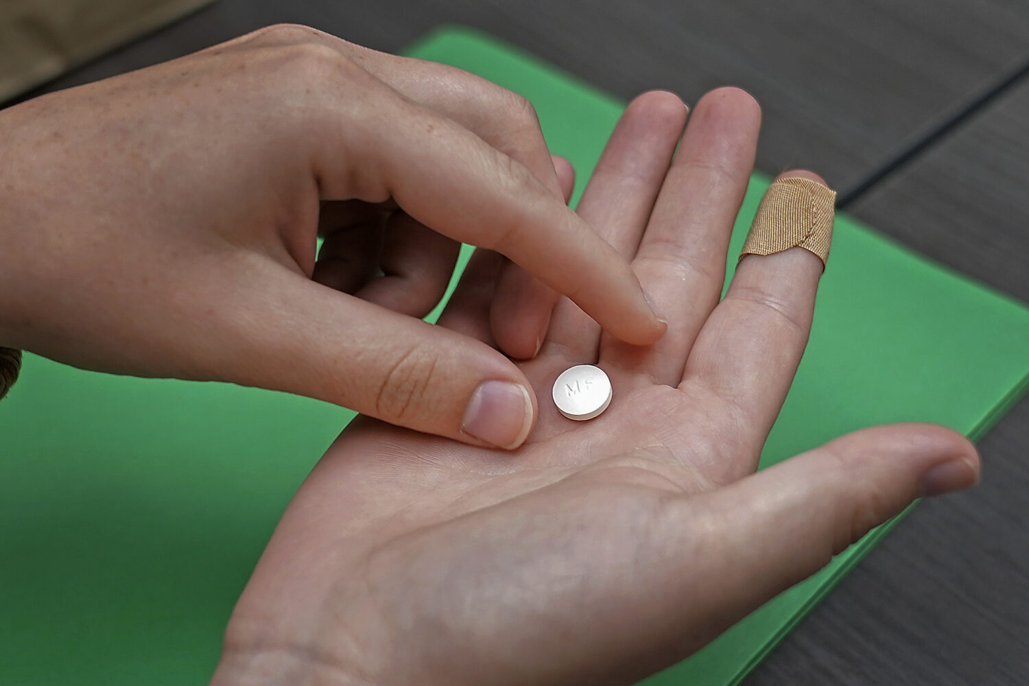 FILE - A patient prepares to take the first of two combination pills, mifepristone, for a medicatio...