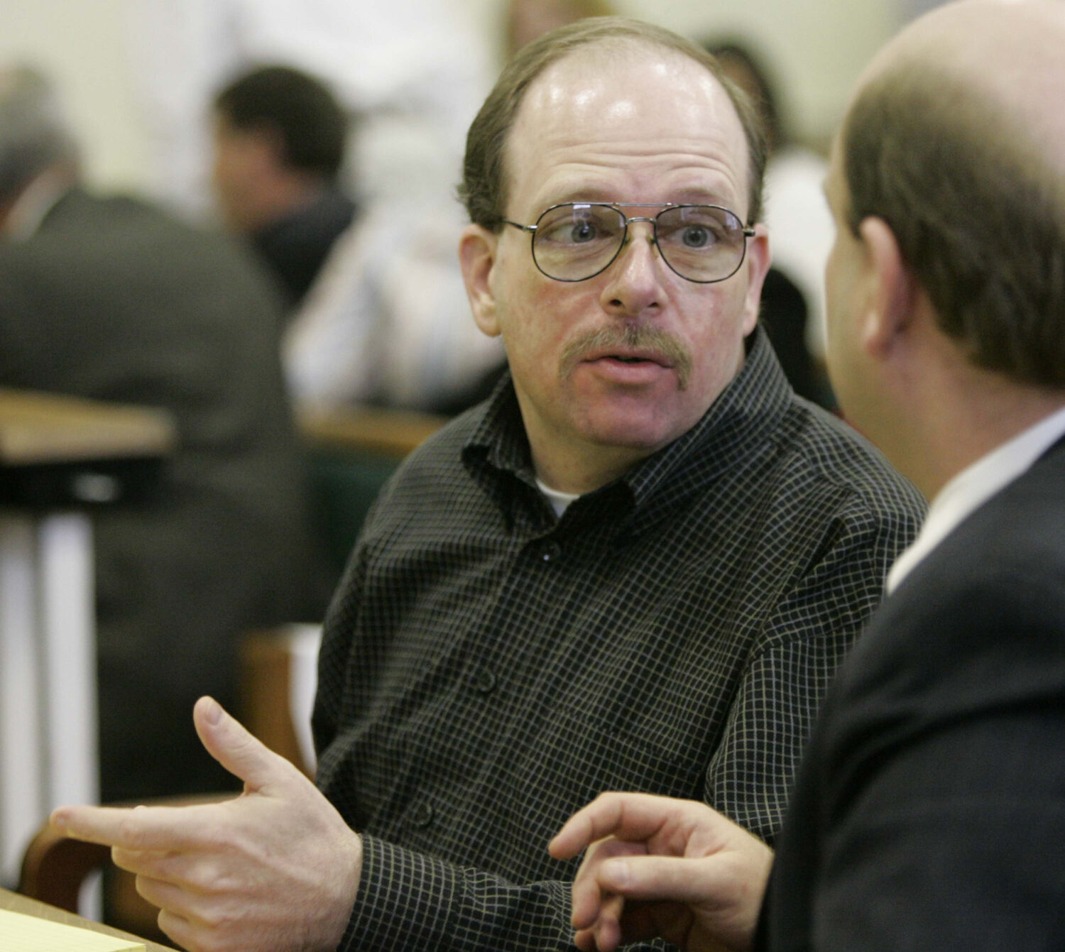 FILE - Steven Bixby, left, talks to his public defender, Charles Grose at the start of his murder t...