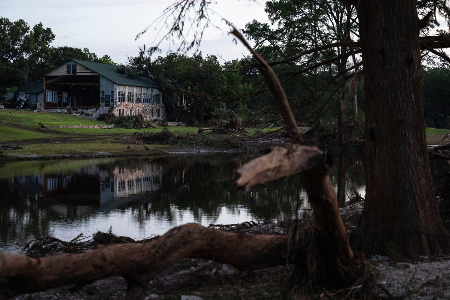 FILE - A building at Camp Mystic is reflected in water after a flash flood swept through the area, ...