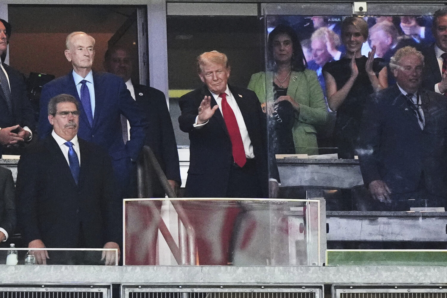 President Donald Trump gestures to people during the seventh inning of a baseball game between the ...