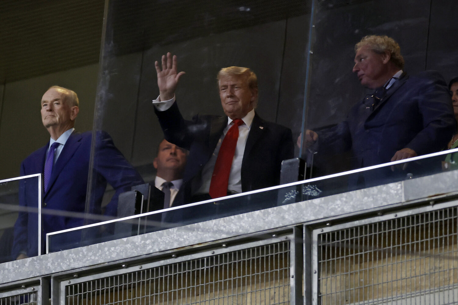 President Donald Trump, center, gestures next to New York Yankees president Randy Levine, front rig...