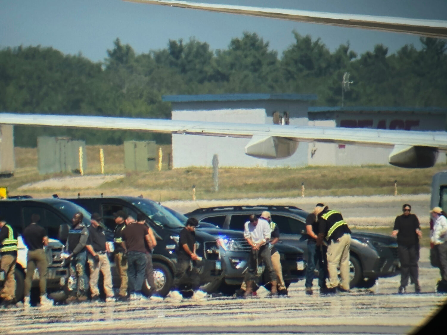 In this photo obtained by the Associated Press, ICE detainees line up to board a flight at Portsmou...