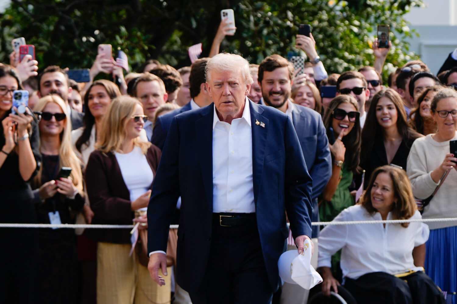 President Donald Trump walks to speak with reporters after greeting supporters before departing the...