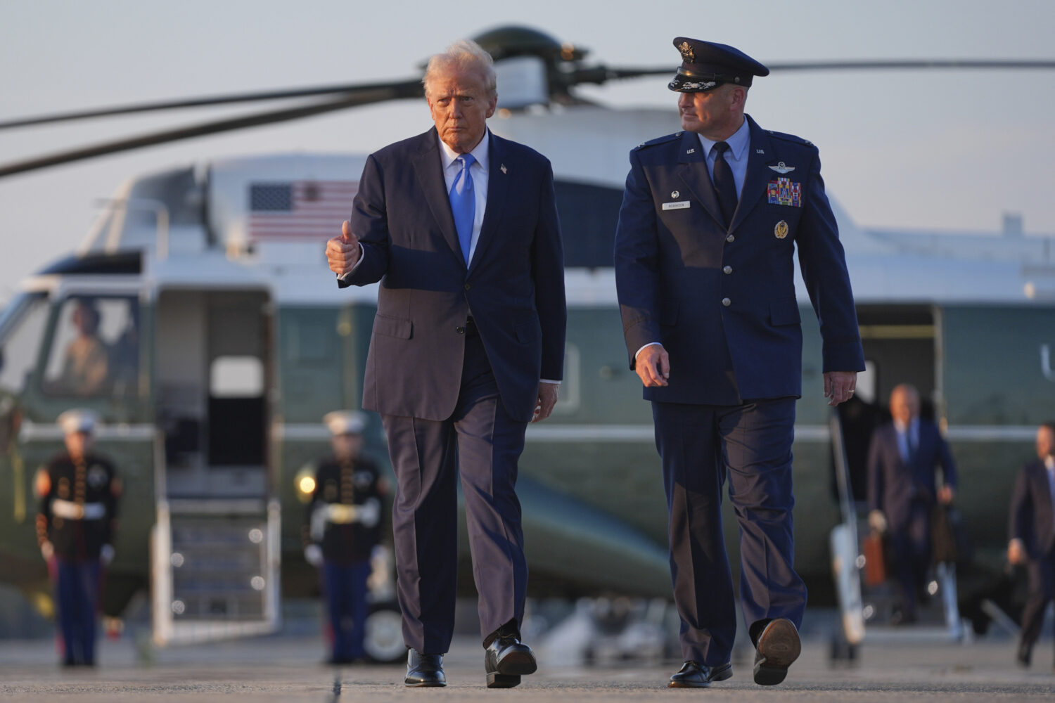 President Donald Trump walks from Marine One with Col. Christopher Robinson, right, commander of th...
