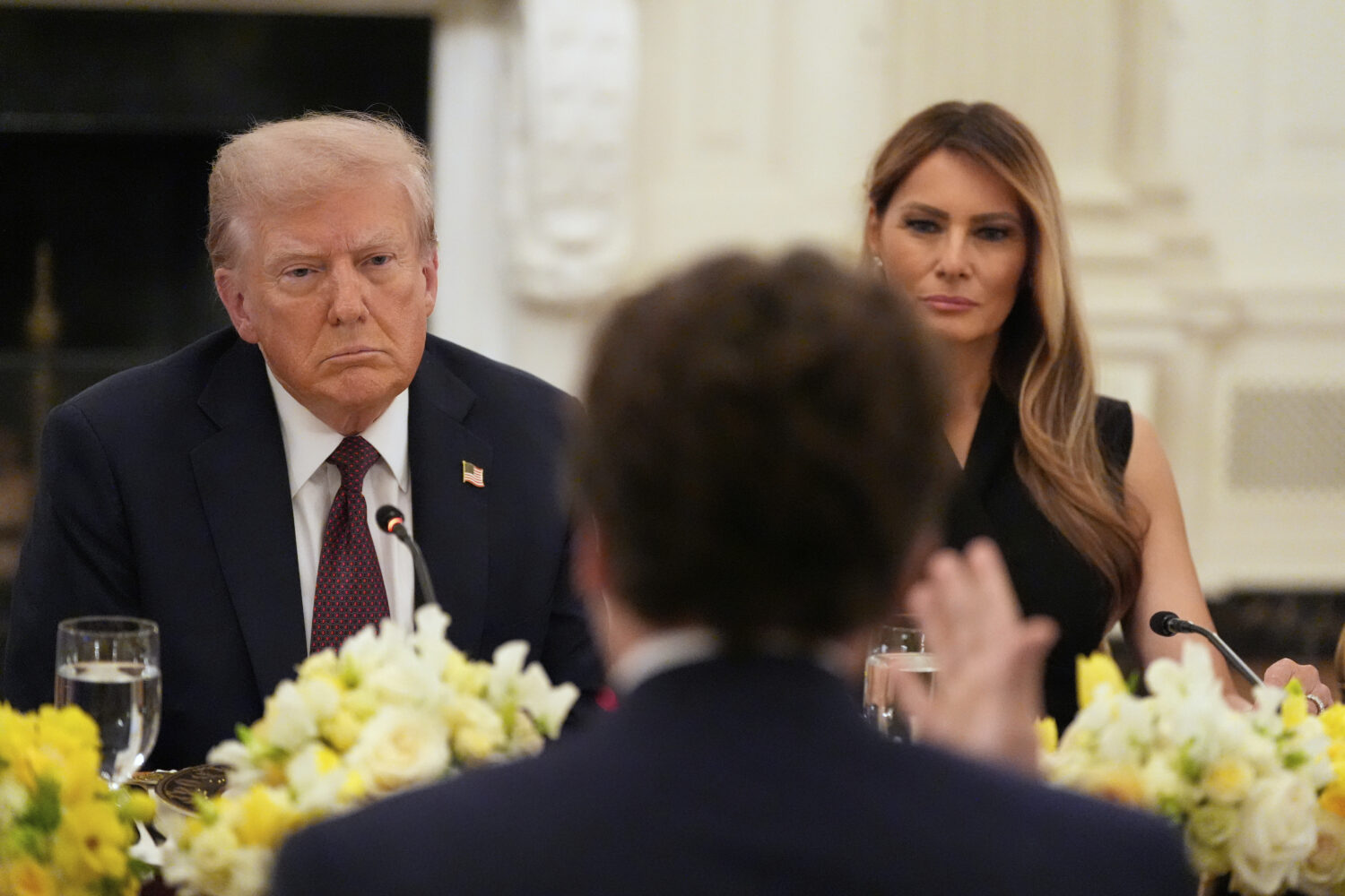President Donald Trump and first lady Melania Trump listen during a dinner in the State Dining Room...