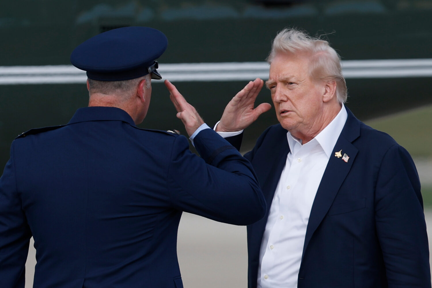 President Donald Trump, right, salutes Air Force Col. Christopher M. Robinson, Commander, 89th Airl...