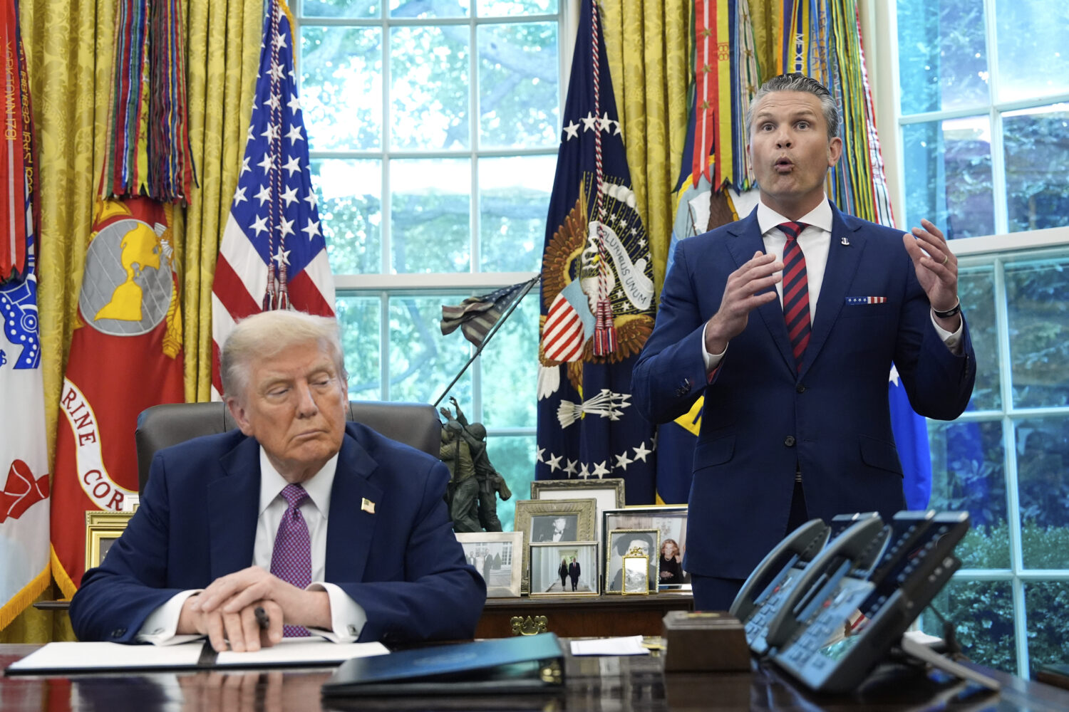 President Donald Trump listens as Defense Secretary Pete Hegseth speaks in the Oval Office of the W...
