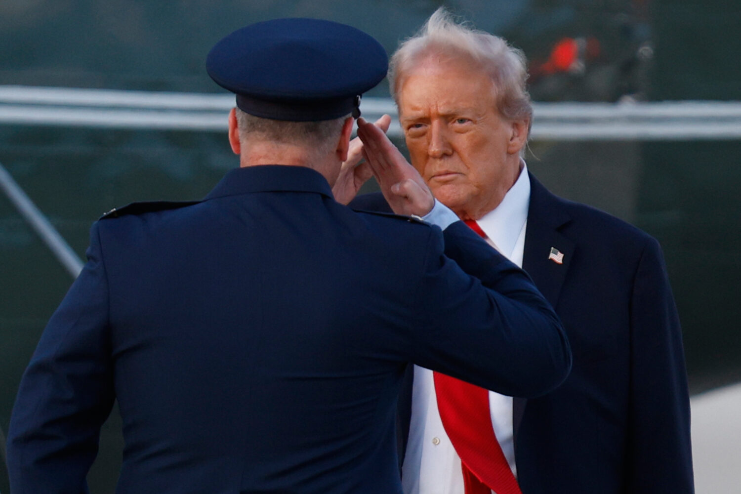 President Donald Trump, right, salutes Air Force Col. Christopher M. Robinson, Commander, 89th Airl...