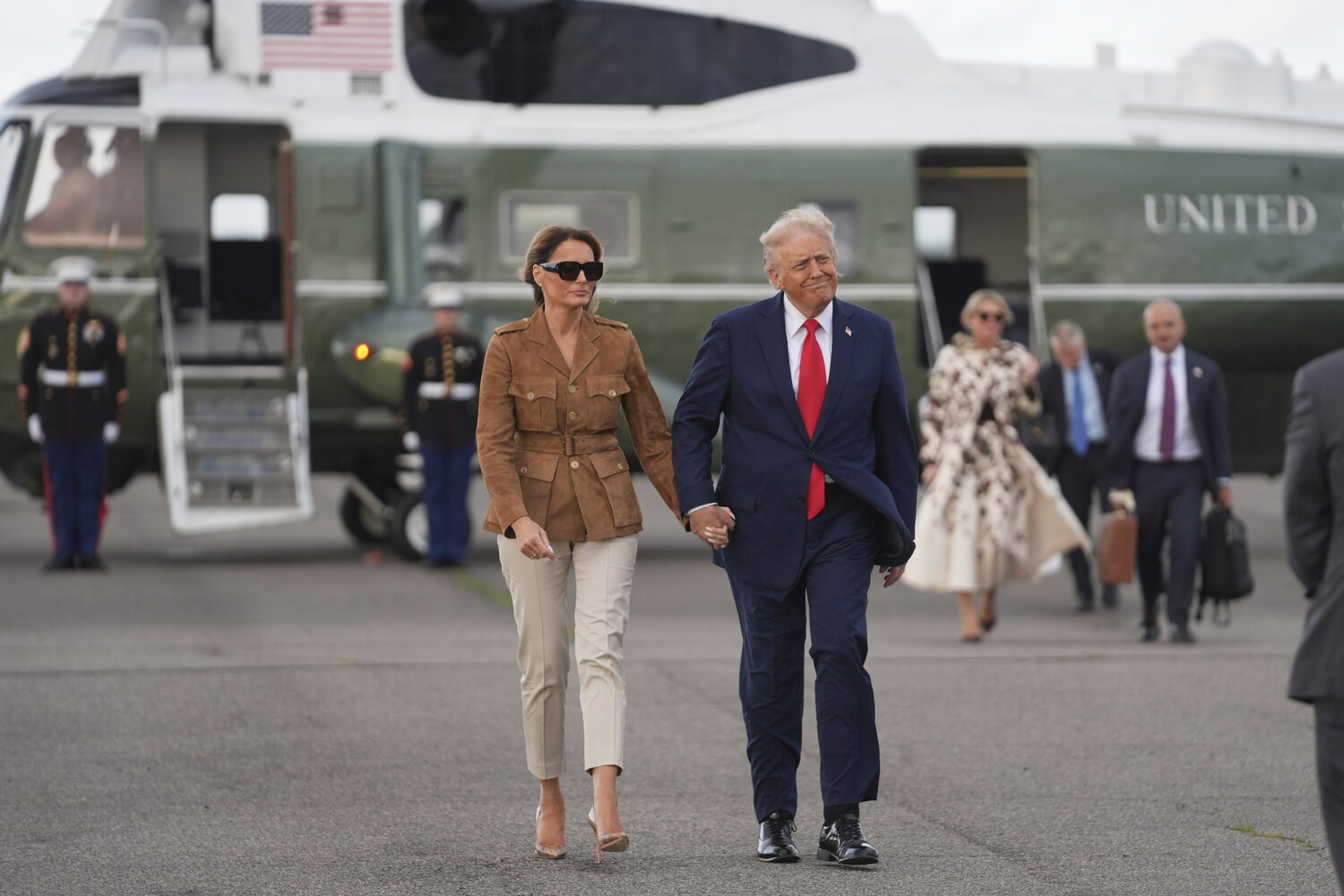 President Donald Trump and first lady Melania Trump walk after arriving on Marine One at Stansted A...