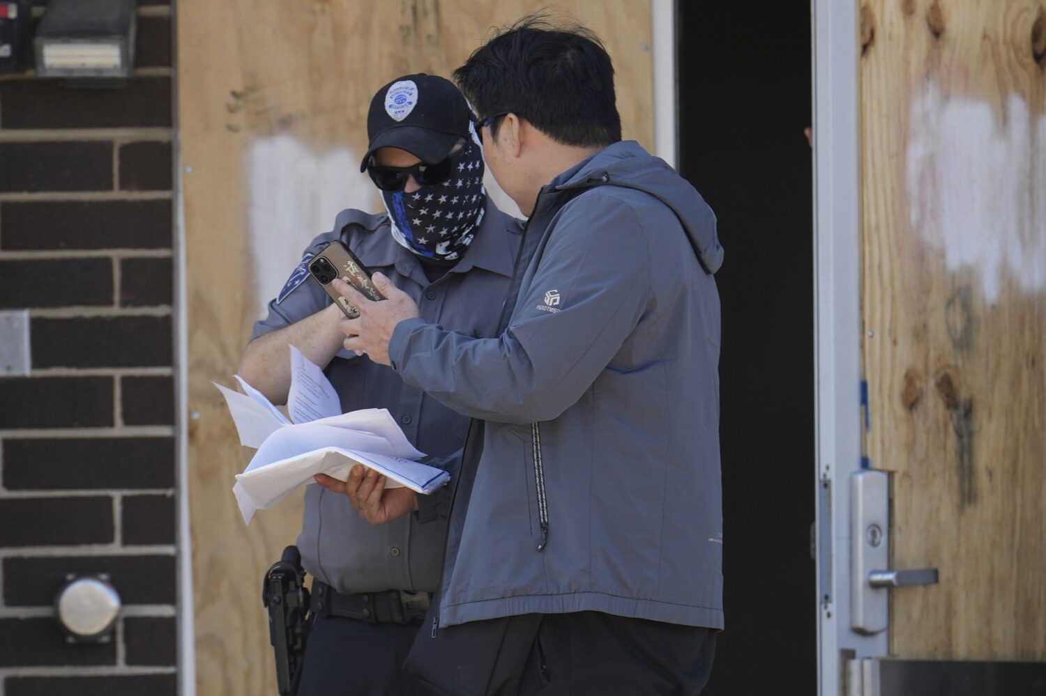 A person talks to a masked guard at the entrance of an immigration processing center Monday, Sept. ...