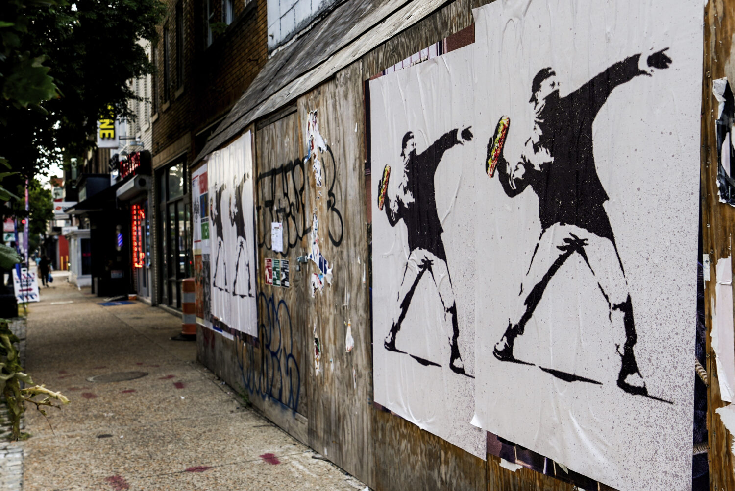 Posters of a person throwing a sandwich are pictured along H Street, Sunday, Aug. 17, 2025, in Wash...