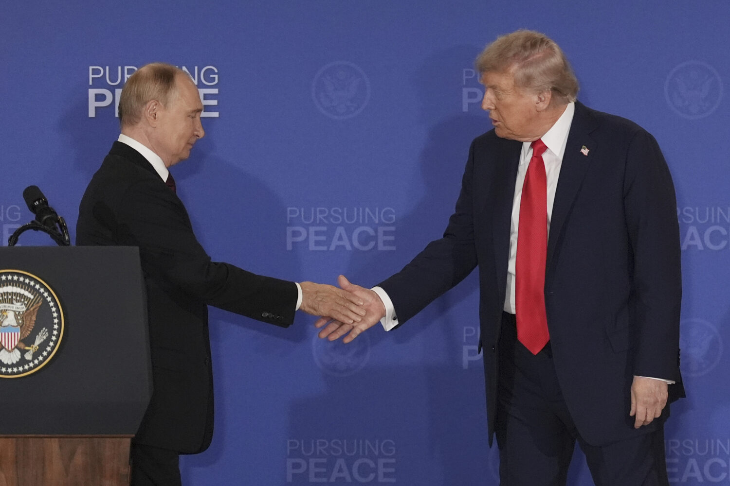 President Donald Trump, right, shakes the hand of Russia's President Vladimir Putin during a joint ...