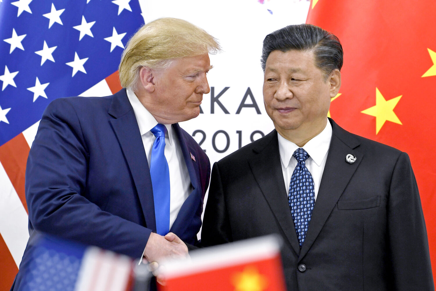 FILE - President Donald Trump, left, shakes hands with China's President Xi Jinping during a meetin...