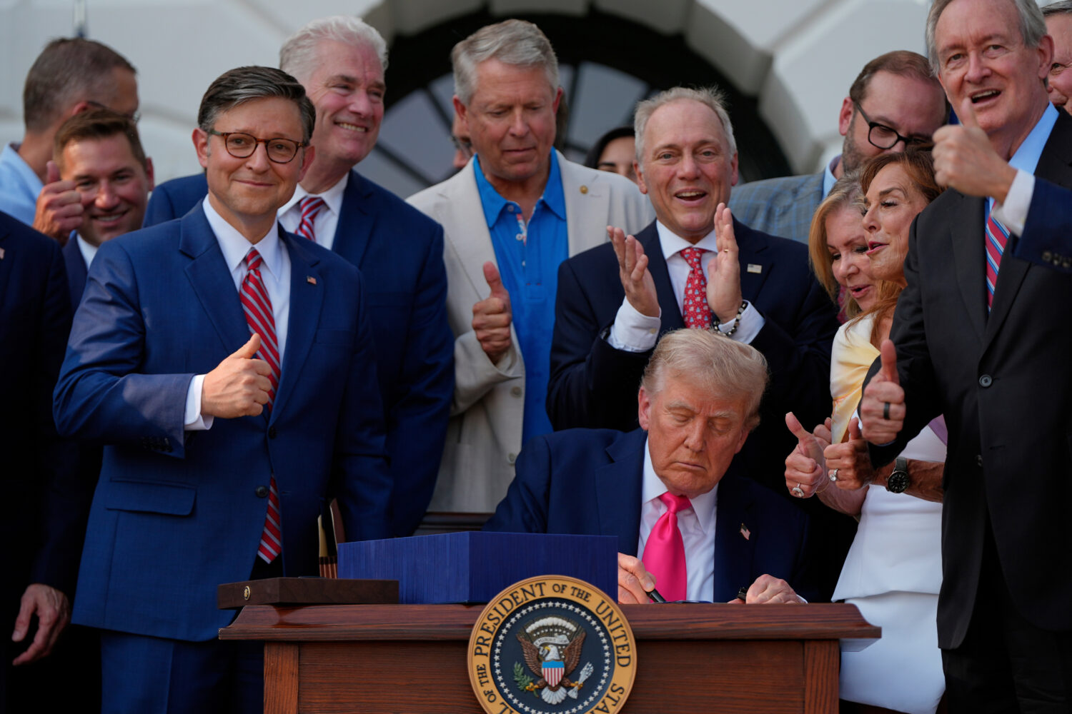 FILE - President Donald Trump signs his signature bill of tax breaks and spending cuts at the White...