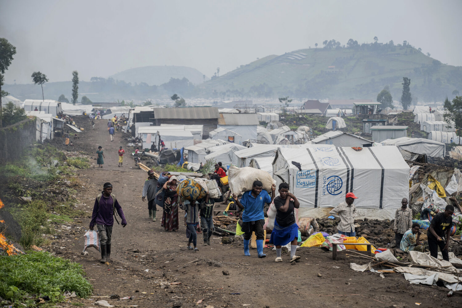 FILE - People who were displaced by the fighting between M23 rebels and government soldiers leave t...