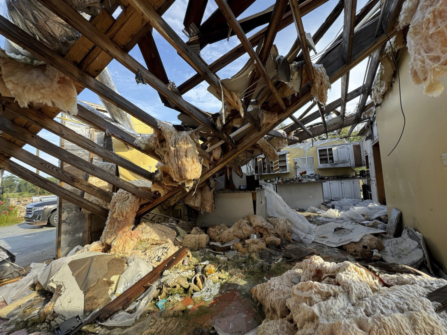 A collapsed roof and insulation cover what used to be Buddy Anthony's kitchen on Thursday, Aug. 14,...