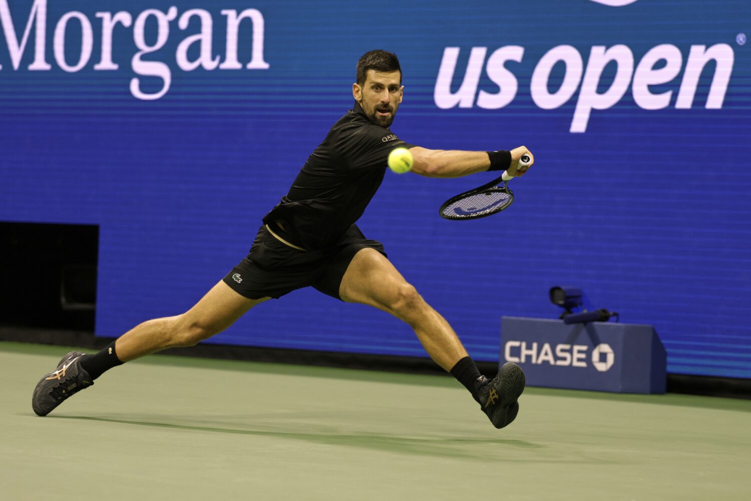 Novak Djokovic, of Serbia, returns a shot against Taylor Fritz, of the United States, during the qu...