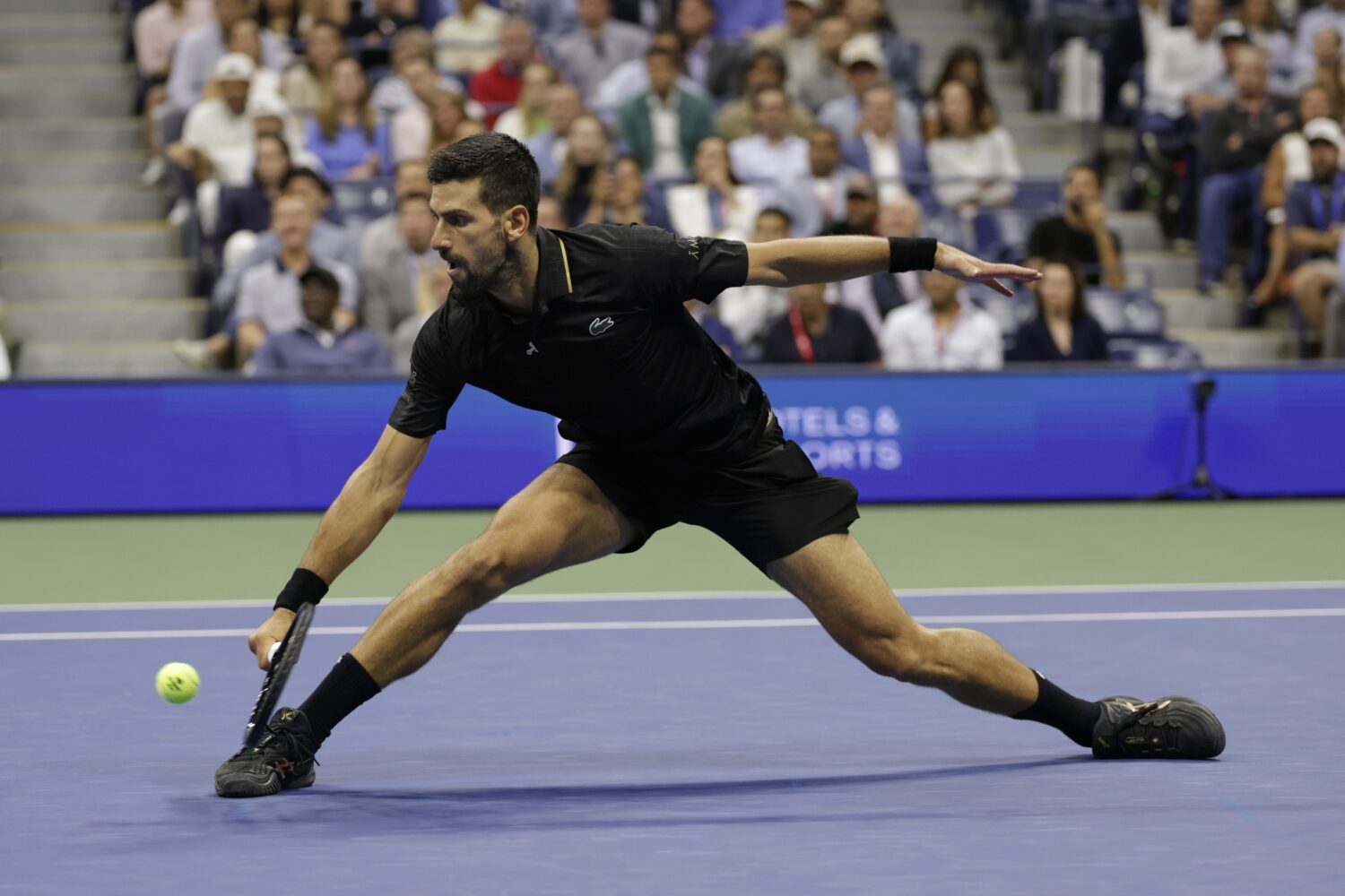 Novak Djokovic, of Serbia, returns a shot against Taylor Fritz, of the United States, during the qu...