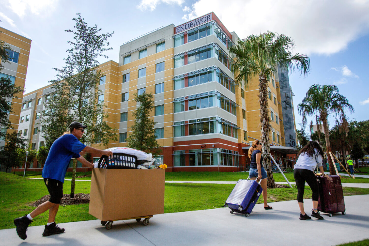 FILE - University of South Florida students walk with suitcases toward a dorm in Tampa on Aug. 16, ...