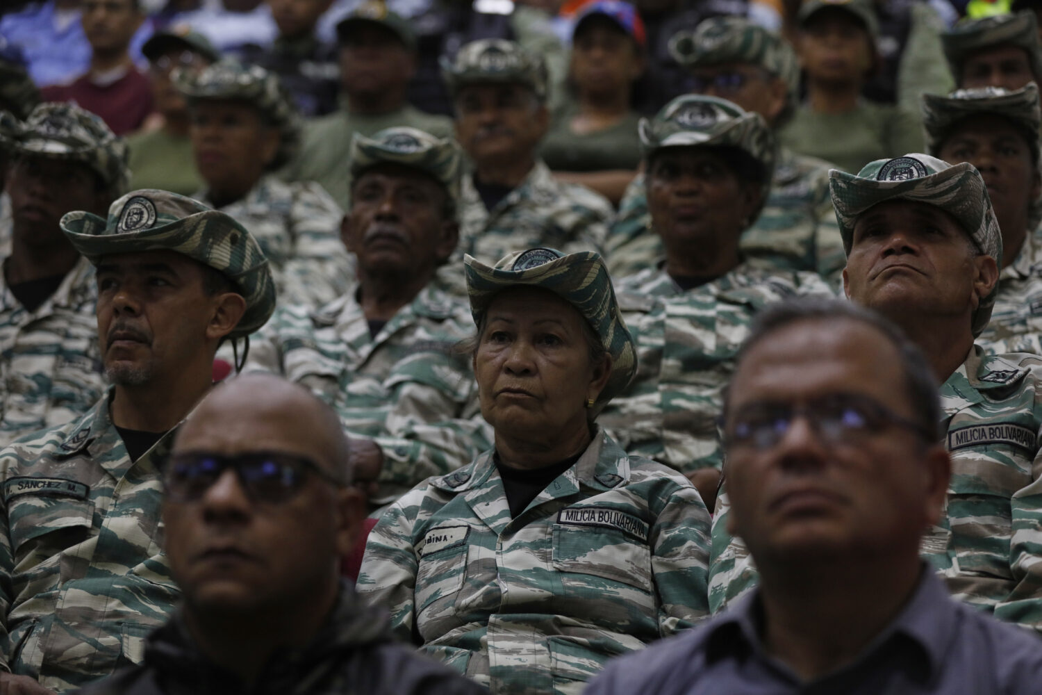 Members of the Bolivarian Militia listen to a recorded speech by President Nicolás Maduro at a mil...