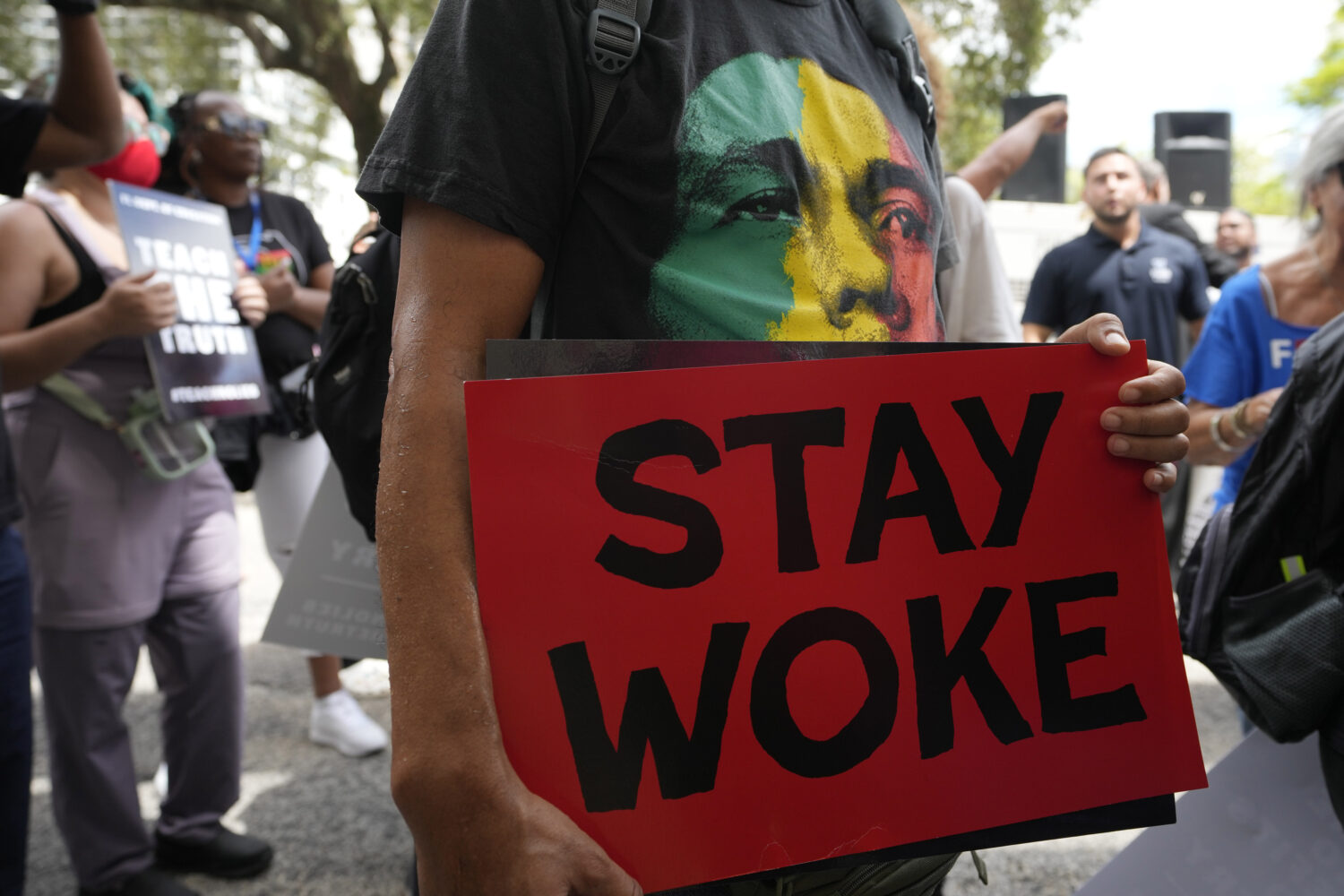 FILE - A person carries a sign during a march to protest Florida's new standards for teaching Black...