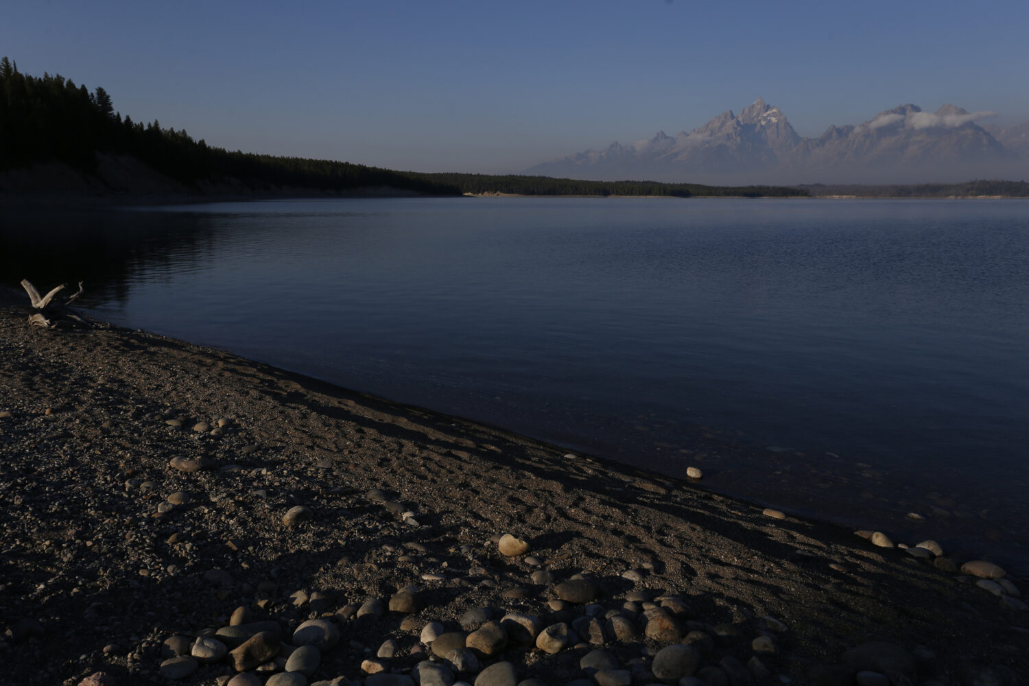 FILE - The sun at dawn illuminates mountain peaks as seen from the shore of Jackson Lake in Grand T...