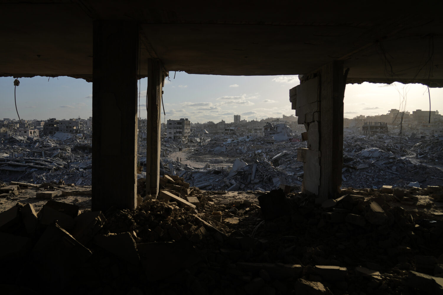 Displaced Palestinians walk amid destroyed buildings in the heavily damaged Sheikh Radwan neighborh...