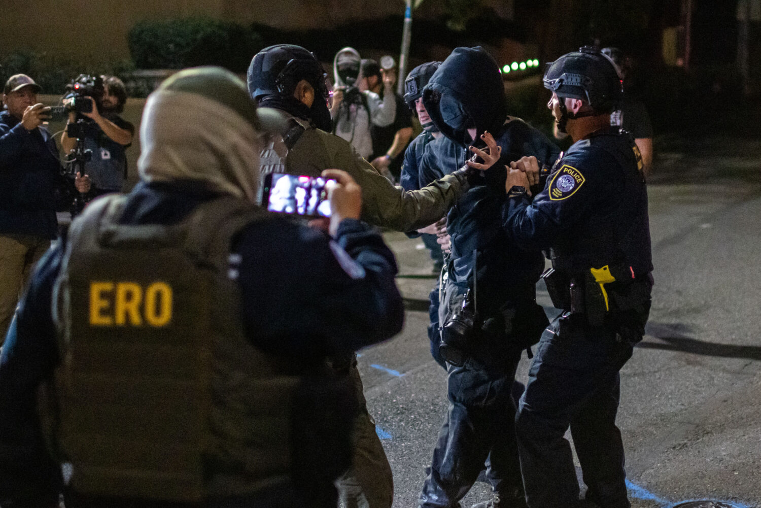 A protester is arrested by police and federal officers outside a U.S. Immigration and Customs Enfor...