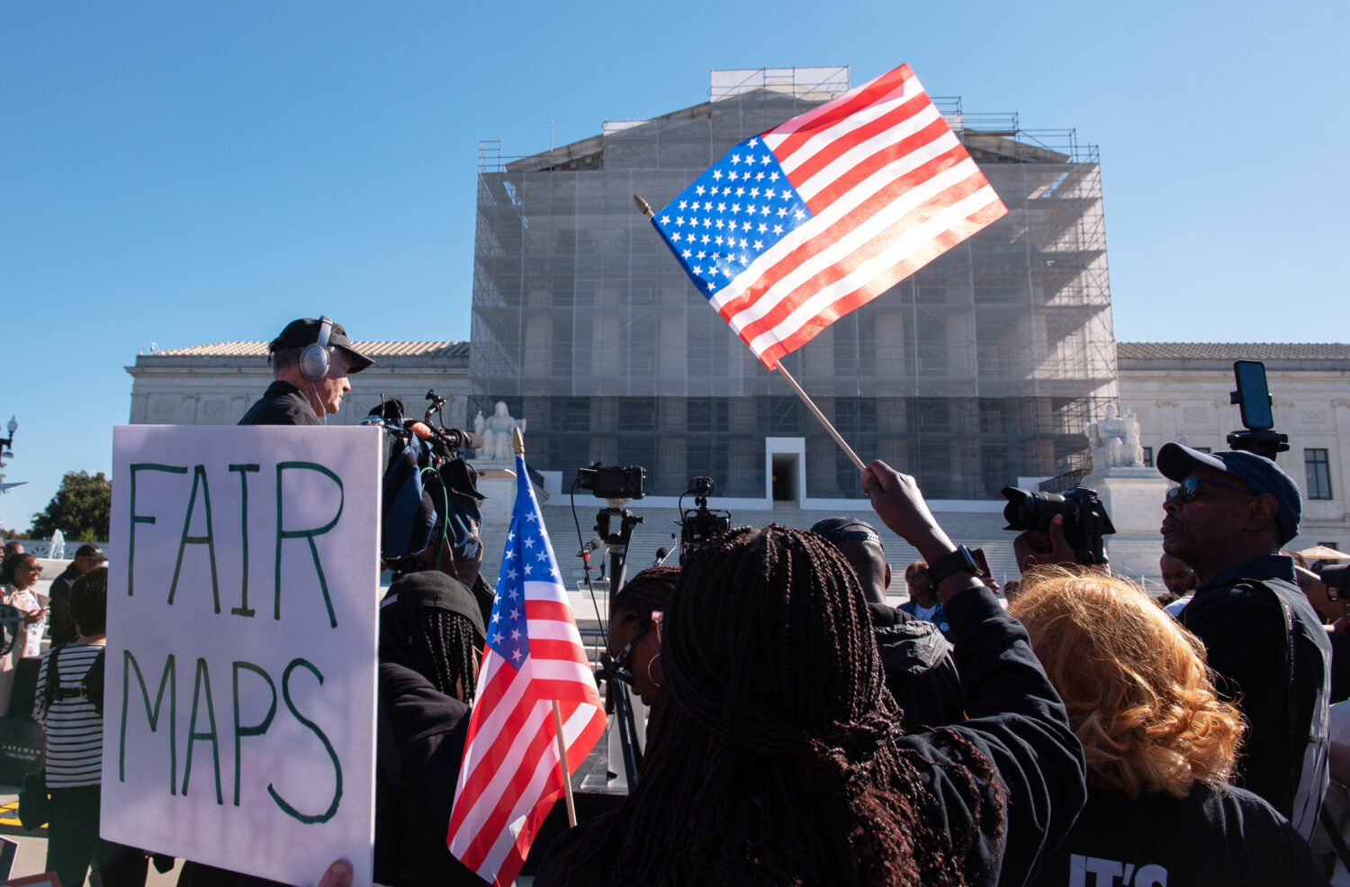 Voting rights activists gather outside the Supreme Court in Washington, early Wednesday, Oct. 15, 2...