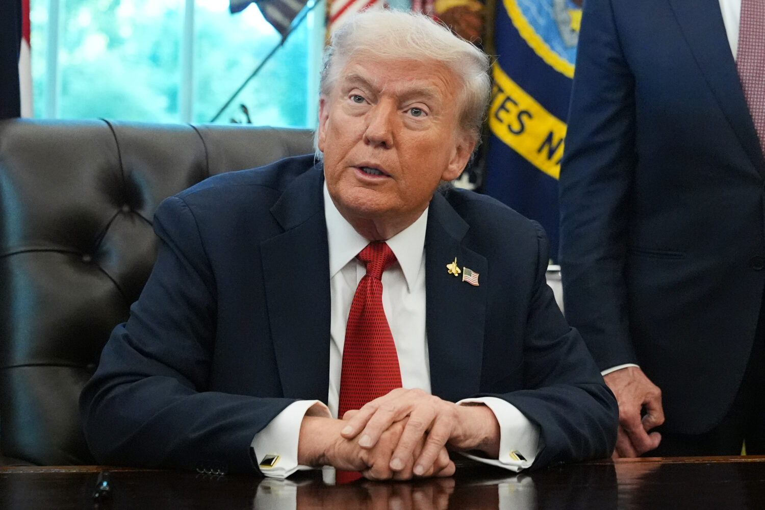President Donald Trump speaks to reporters before signing an executive order in the Oval Office at ...