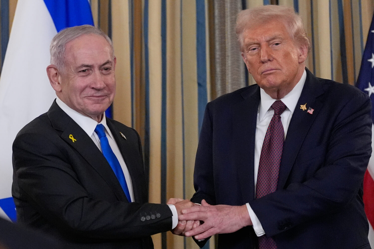 Israel's Prime Minister Benjamin Netanyahu shakes hands with President Donald Trump after a news co...