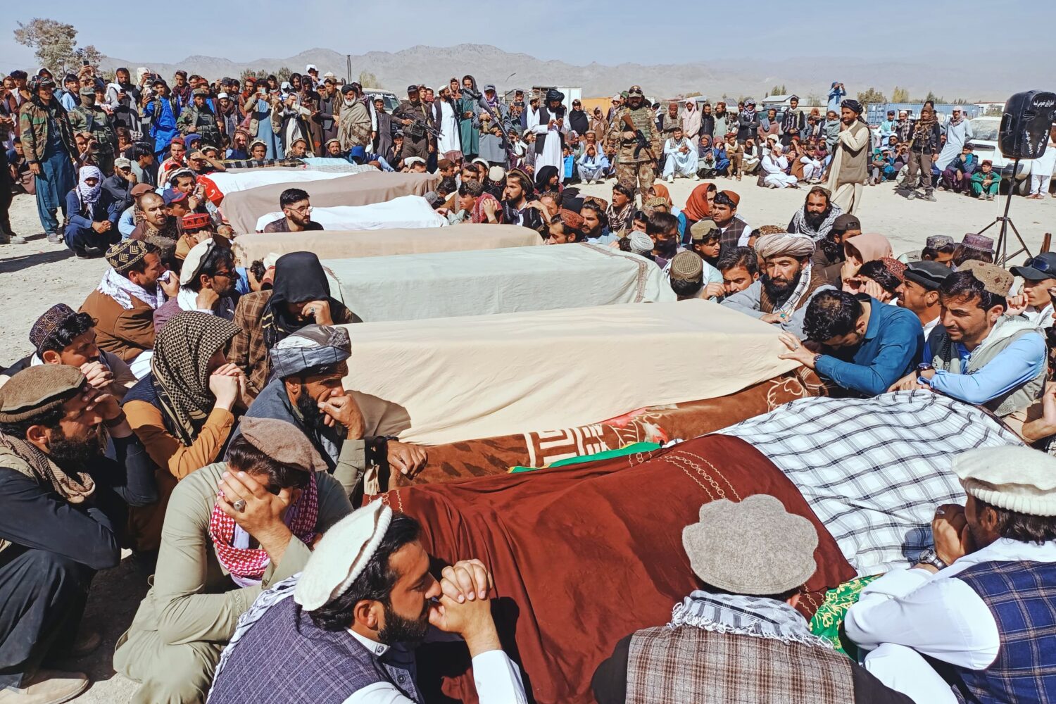 Local residents pray over the bodies of victims of a Pakistani cross-border airstrike, including th...